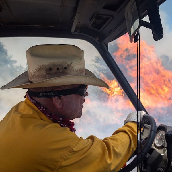 chuck coffey driving through prescribed fire on his ranch in Arbuckle Mountains, Oklahoma